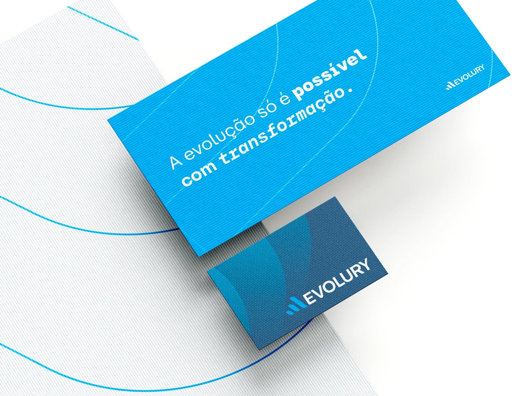 Papelaria da Evolury com cartões e materiais impressos sobre superfície clara.